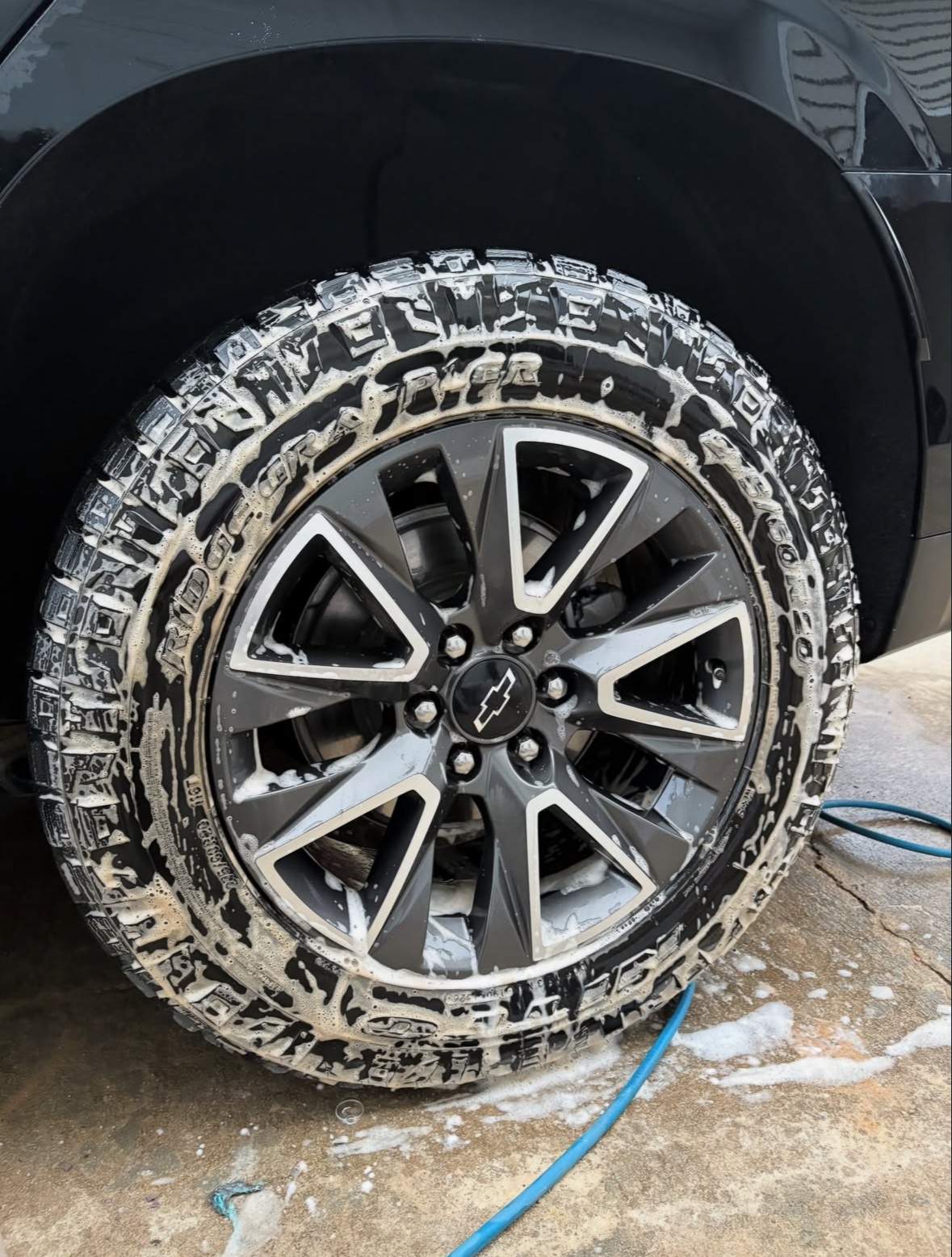 Chevrolet wheel and tire covered in cleaning foam